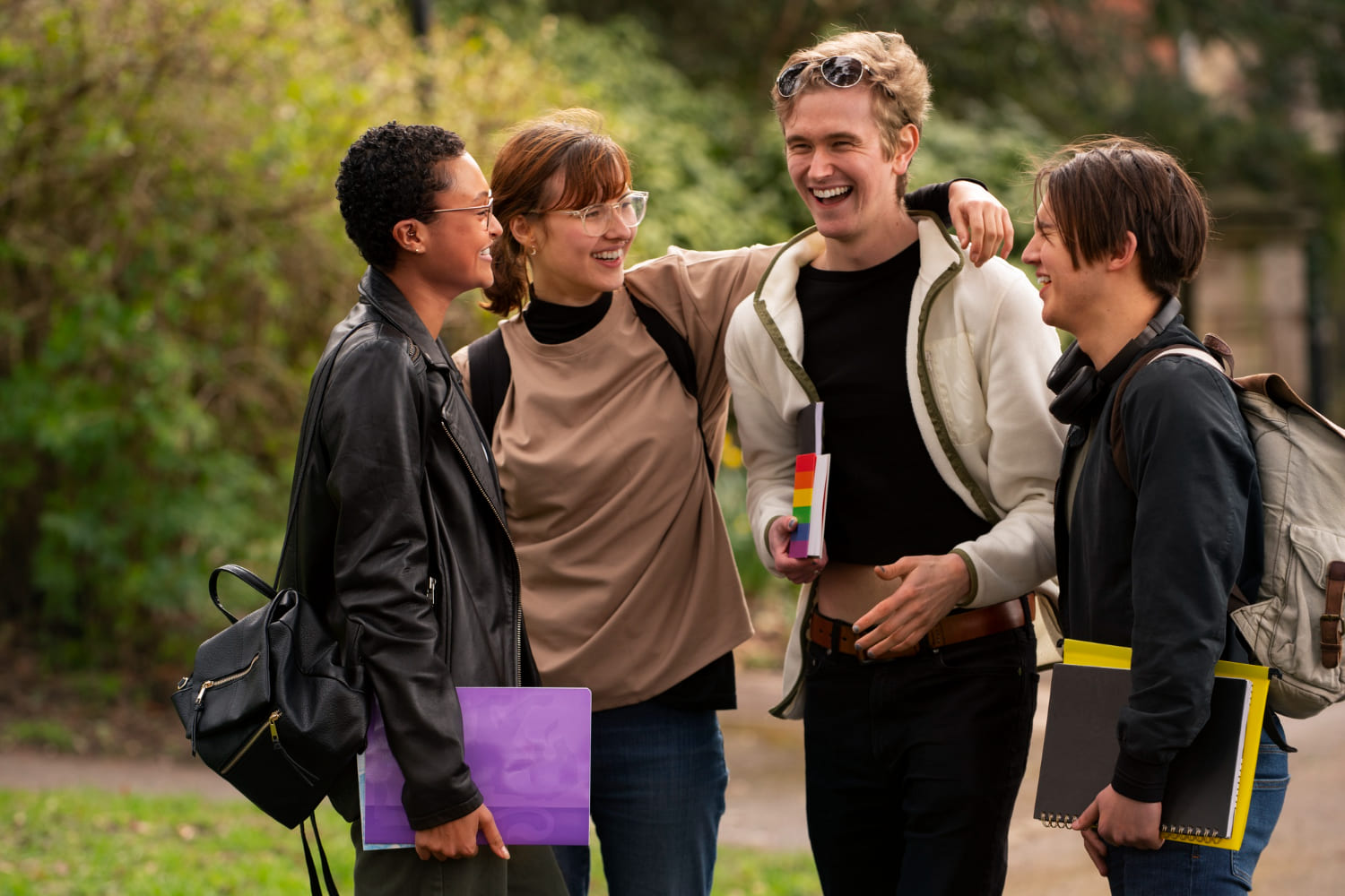 How to make friends in college, fun and authentic ways to connect College students laughing together on campus lawn